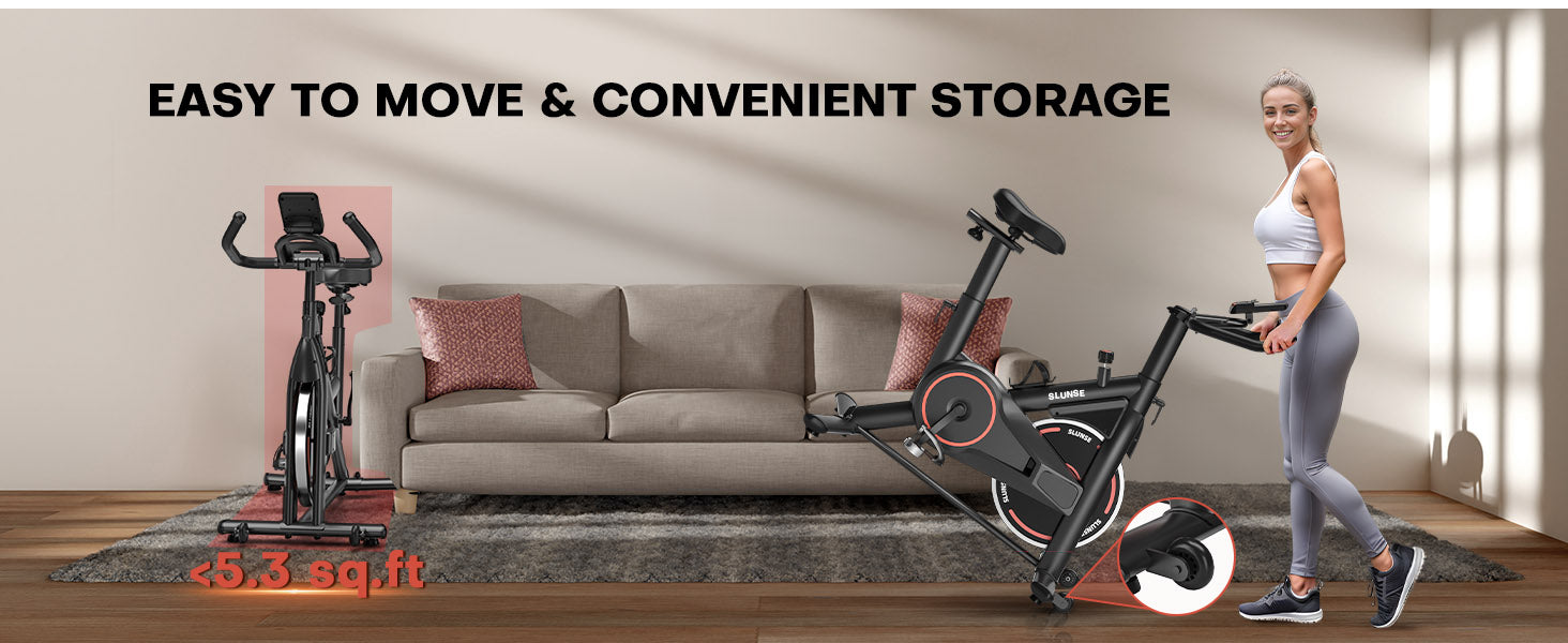 Exercise bike with a woman standing next to it, placed on a wooden floor in a living room setting.